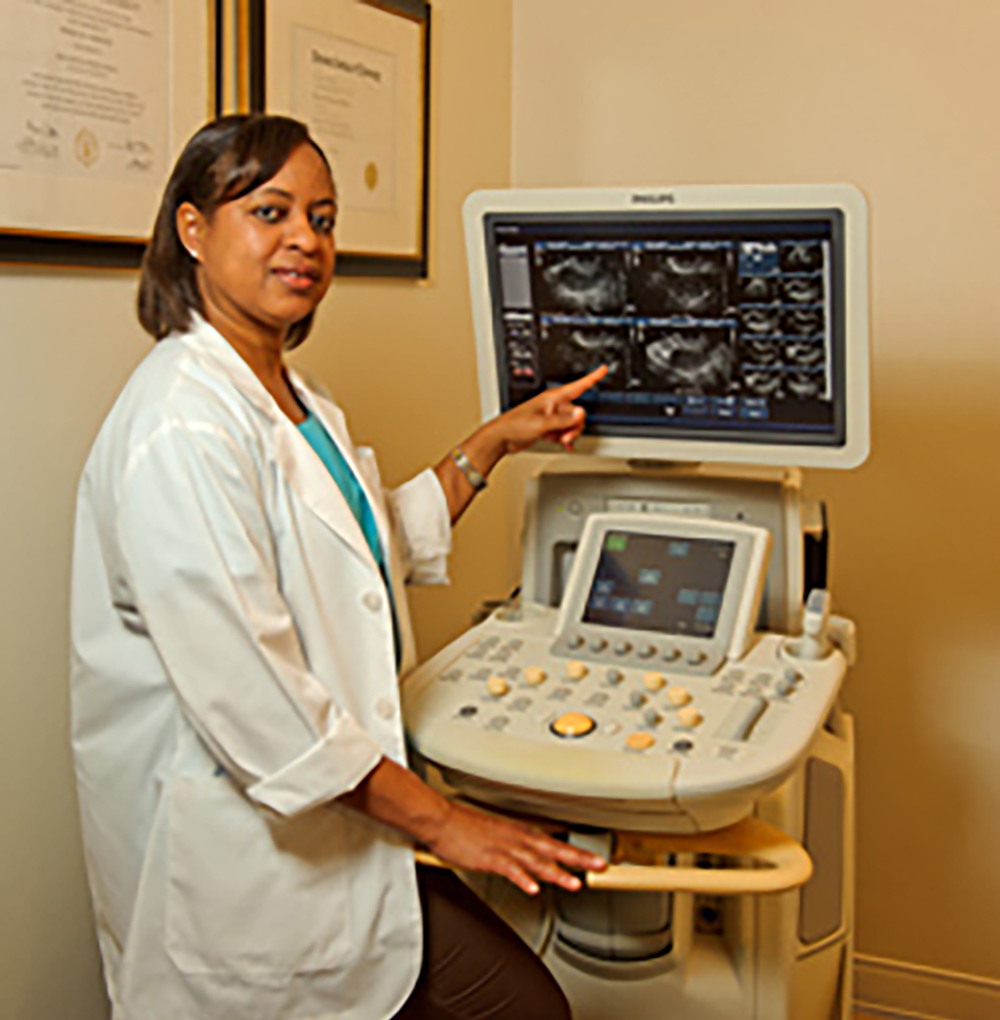 Denika M. Reid beside Sonoview ultrasound equipment